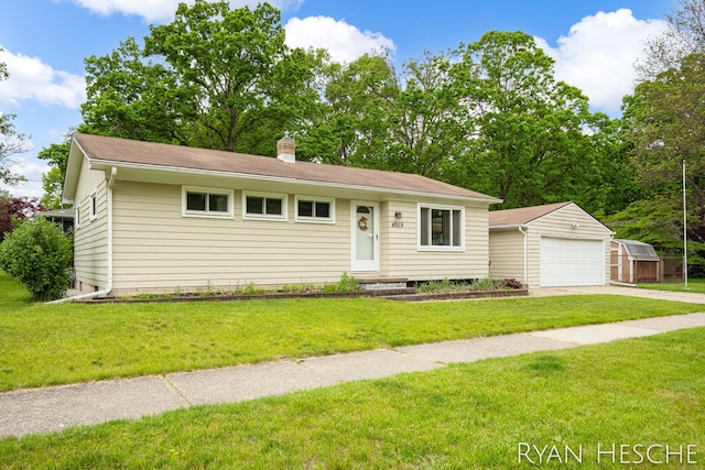 4959 Havana Ave SW, Wyoming, MI 49509 - view of front facade with an outdoor structure, a detached garage, a chimney, and a front yard