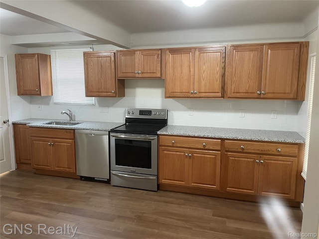 14275 Young St, Detroit, MI 48205 - kitchen featuring appliances with stainless steel finishes, a sink, tasteful backsplash, dark wood-style floors, and brown cabinets
