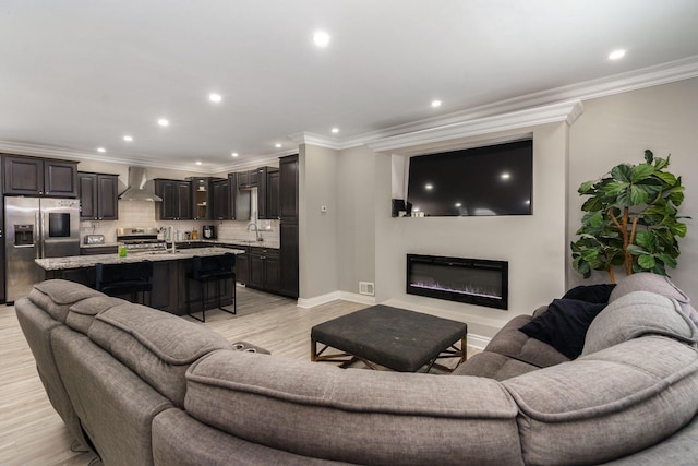 719 Webb St, Detroit, MI 48202 - living room featuring ornamental molding, light wood-style floors, a glass covered fireplace, baseboards, and recessed lighting