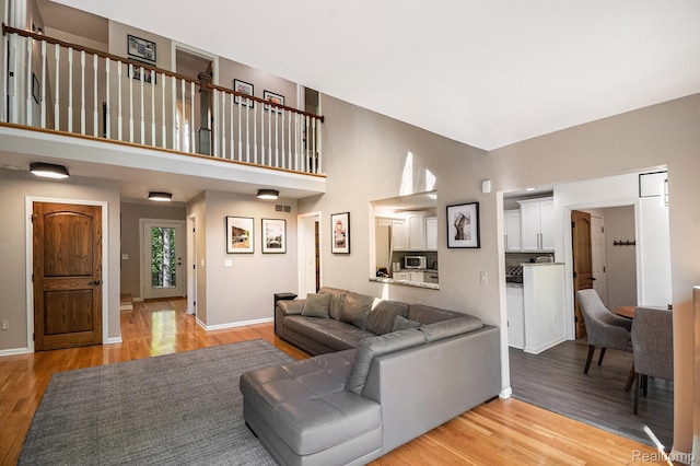 8315 Woodland Cir, Goodrich, MI 48438 - living area with light wood finished floors, baseboards, and a high ceiling