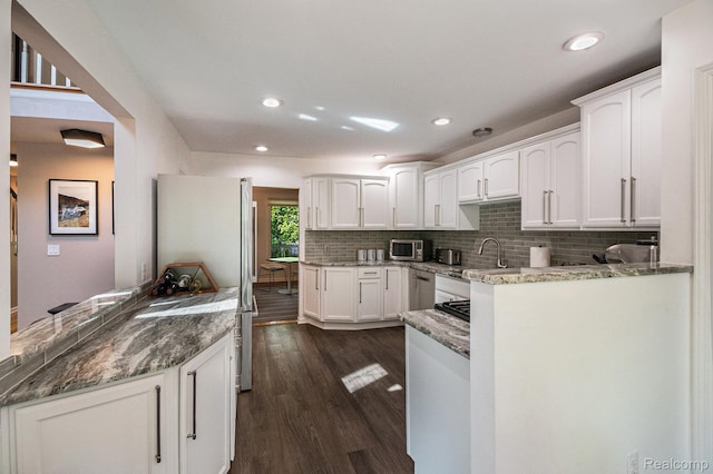 8315 Woodland Cir, Goodrich, MI 48438 - kitchen with appliances with stainless steel finishes, white cabinets, dark wood-type flooring, backsplash, and stone countertops