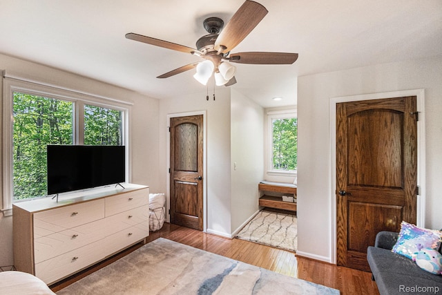 8315 Woodland Cir, Goodrich, MI 48438 - bedroom featuring multiple windows, wood finished floors, baseboards, and ceiling fan