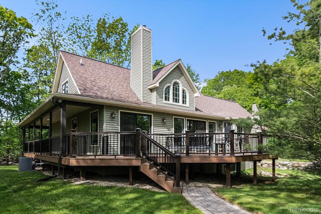 8315 Woodland Cir, Goodrich, MI 48438 - rear view of house featuring a yard, roof with shingles, a deck, and a chimney