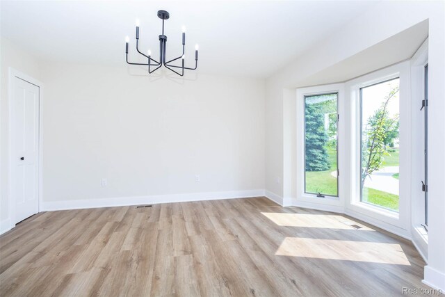 56259 Schoenherr Rd, Shelby Twp, MI 48315 - unfurnished dining area with a chandelier, light wood-style flooring, and baseboards