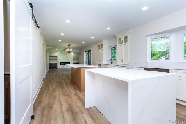 56259 Schoenherr Rd, Shelby Twp, MI 48315 - kitchen featuring a kitchen island, recessed lighting, open floor plan, light wood-style floors, and white cabinets