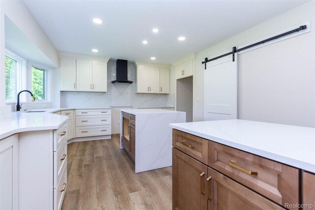 56259 Schoenherr Rd, Shelby Twp, MI 48315 - kitchen with wall chimney exhaust hood, a barn door, a sink, light wood-style floors, and recessed lighting