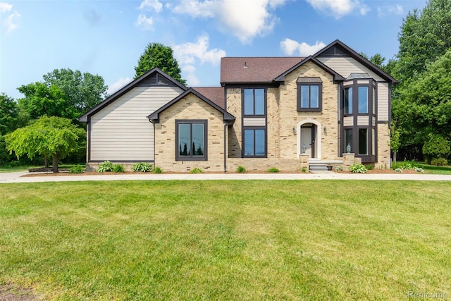 56259 Schoenherr Rd, Shelby Twp, MI 48315 - tudor-style house with brick siding, a front lawn, and a shingled roof