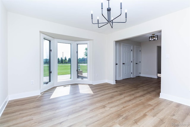 56259 Schoenherr Rd, Shelby Twp, MI 48315 - unfurnished dining area with a chandelier, baseboards, and light wood finished floors