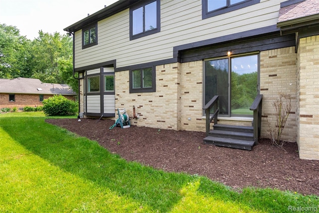 56259 Schoenherr Rd, Shelby Twp, MI 48315 - back of house featuring entry steps, a yard, and brick siding