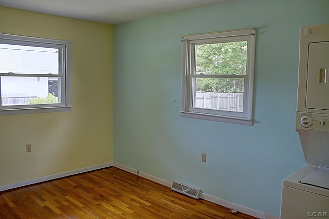 2683 Elmwood Dr, Adrian, MI 49221 - spare room with stacked washing machine and dryer, wood finished floors, and baseboards