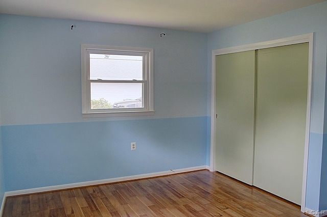 2683 Elmwood Dr, Adrian, MI 49221 - unfurnished bedroom with wood finished floors, a closet, and baseboards