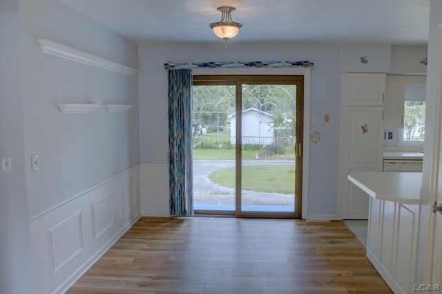 2683 Elmwood Dr, Adrian, MI 49221 - unfurnished dining area featuring light wood-style floors and wainscoting