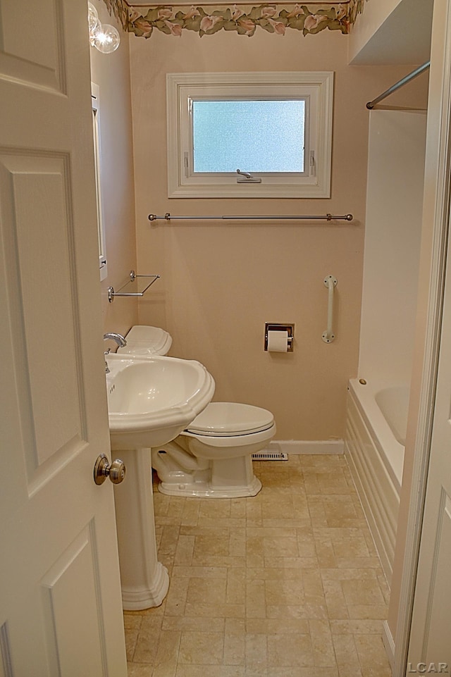 2683 Elmwood Dr, Adrian, MI 49221 - full bath featuring baseboards, toilet, tub / shower combination, and stone finish flooring