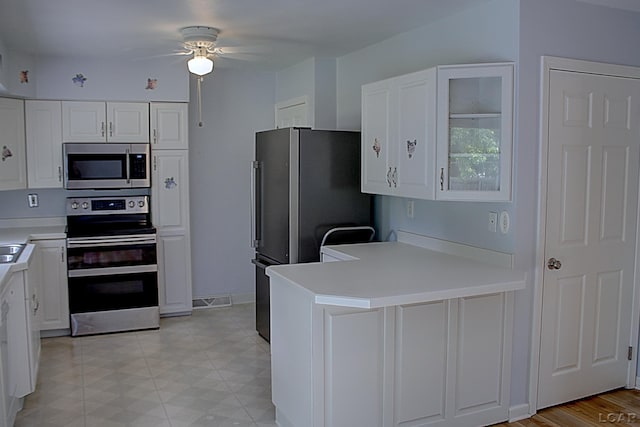 2683 Elmwood Dr, Adrian, MI 49221 - kitchen with stainless steel appliances, a ceiling fan, a peninsula, and white cabinetry
