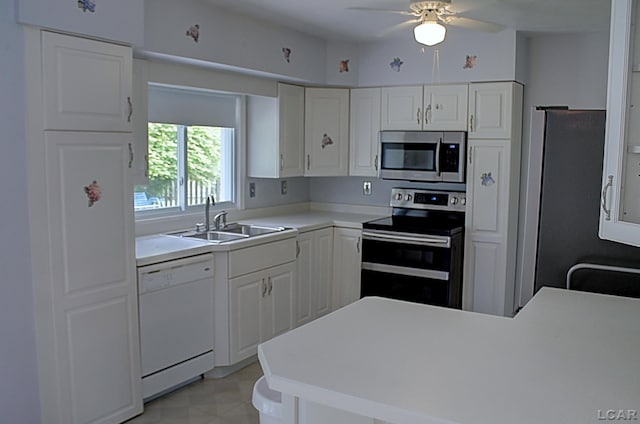 2683 Elmwood Dr, Adrian, MI 49221 - kitchen featuring appliances with stainless steel finishes, a sink, a peninsula, white cabinetry, and ceiling fan