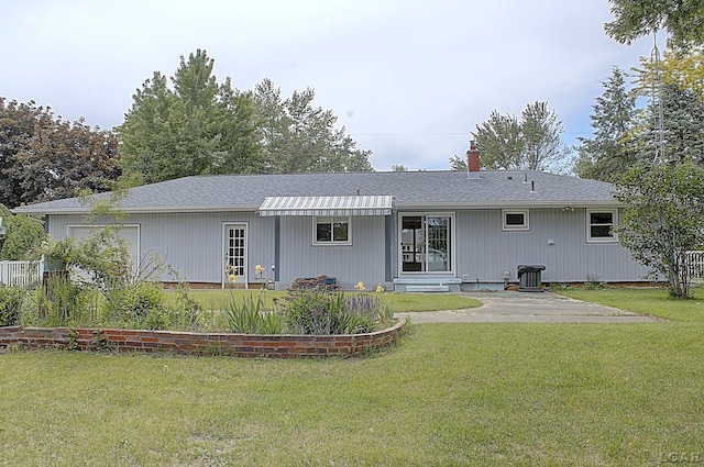 2683 Elmwood Dr, Adrian, MI 49221 - rear view of house with a yard, a chimney, and central air condition unit