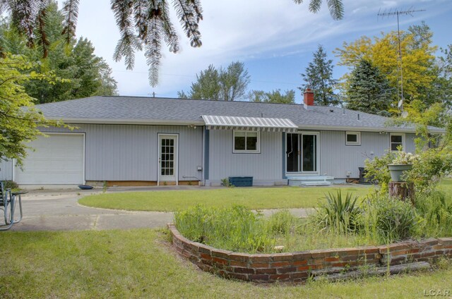 2683 Elmwood Dr, Adrian, MI 49221 - rear view of property featuring a garage, a shingled roof, a yard, and a chimney