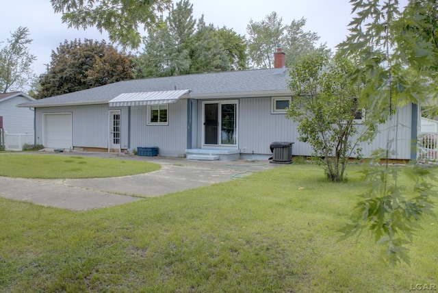 2683 Elmwood Dr, Adrian, MI 49221 - back of house featuring a chimney, a shingled roof, a garage, and central AC