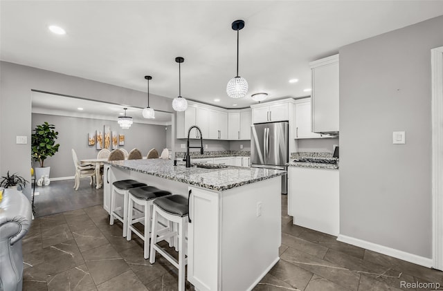 24970 Thorndyke St, Southfield, MI 48033 - kitchen featuring freestanding refrigerator, recessed lighting, white cabinetry, a breakfast bar area, and light stone countertops