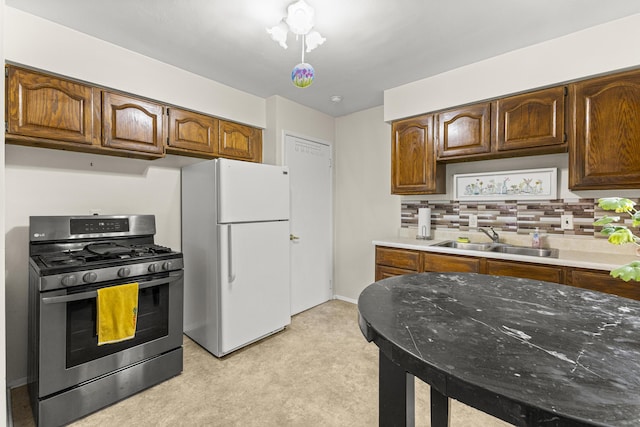 15944 Meyer Ave, Allen Park, MI 48101 - kitchen featuring stainless steel gas stove, freestanding refrigerator, a sink, light carpet, and backsplash