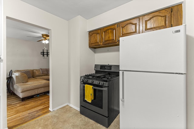 15944 Meyer Ave, Allen Park, MI 48101 - kitchen with freestanding refrigerator, gas range, a ceiling fan, baseboards, and brown cabinets
