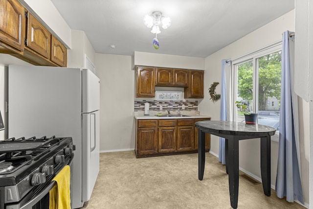 15944 Meyer Ave, Allen Park, MI 48101 - kitchen with light carpet, light countertops, tasteful backsplash, stainless steel range with gas stovetop, and a sink