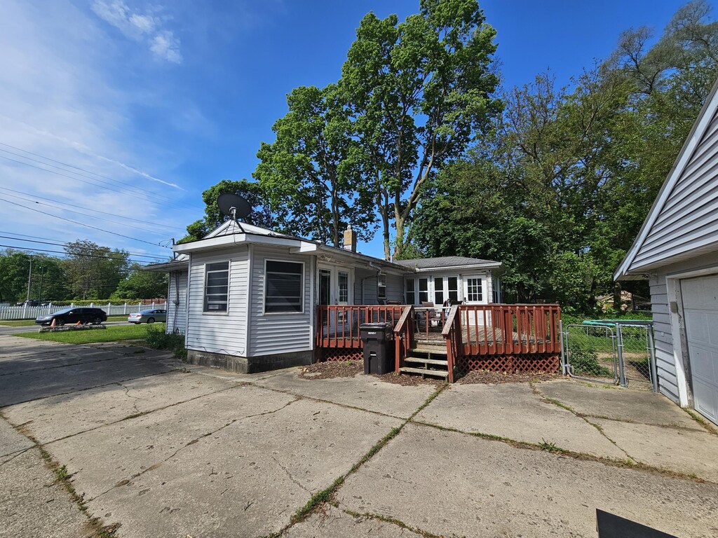 607 66th St SE, Grand Rapids, MI 49548 - rear view of house featuring a wooden deck and a chimney