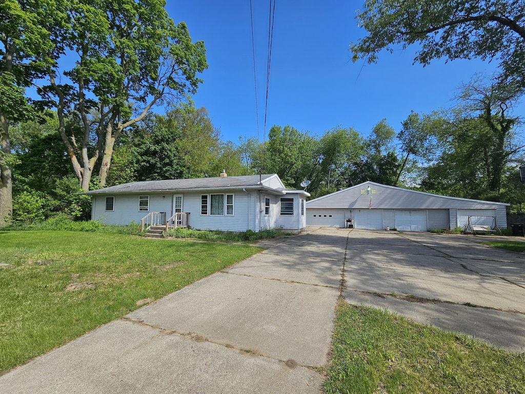 607 66th St SE, Grand Rapids, MI 49548 - view of front of home with a detached garage, a front yard, and an outdoor structure