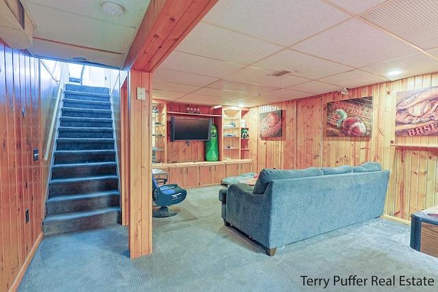 607 66th St SE, Grand Rapids, MI 49548 - carpeted living room with wooden walls, stairs, and a paneled ceiling