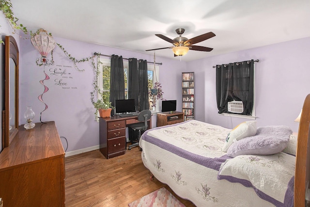 299 5th Ave, Manistee, MI 49660 - bedroom featuring wood finished floors, a desk, baseboards, ceiling fan, and cooling unit