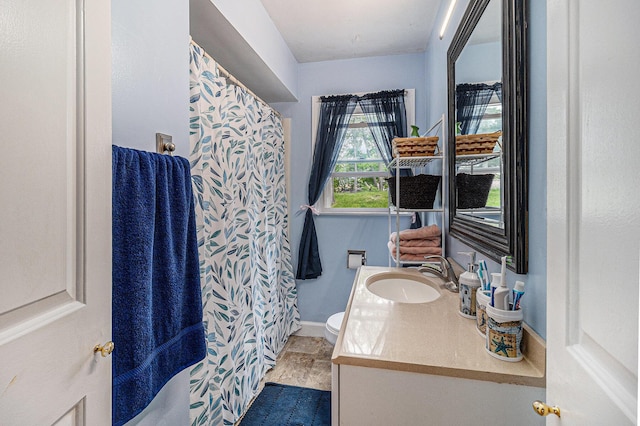 299 5th Ave, Manistee, MI 49660 - full bathroom with vanity, toilet, baseboards, and a shower with shower curtain