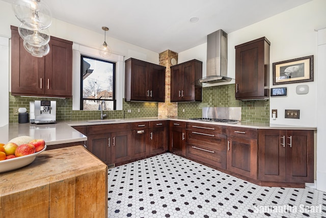 573 College Ave SE, Grand Rapids, MI 49503 - kitchen featuring extractor fan, a sink, stainless steel gas stovetop, light countertops, and backsplash