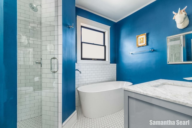 573 College Ave SE, Grand Rapids, MI 49503 - full bath featuring a shower stall, vanity, a freestanding tub, crown molding, and tile patterned floors