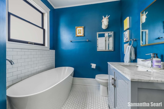 573 College Ave SE, Grand Rapids, MI 49503 - full bath featuring a freestanding bath, vanity, toilet, baseboards, and tile patterned floors