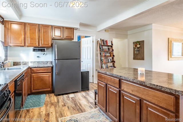 4879 Sundale Dr, Clarkston, MI 48346 - kitchen with freestanding refrigerator, a sink, light wood-style floors, brown cabinets, and range