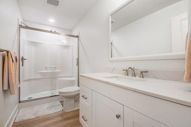 883 Water Ridge Dr, Byron Center, MI 49315 - bathroom featuring wood finished floors, vanity, a shower stall, toilet, and recessed lighting