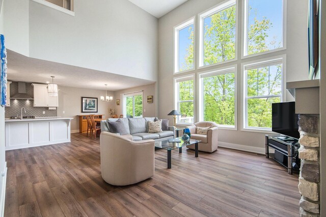 883 Water Ridge Dr, Byron Center, MI 49315 - living area with a towering ceiling, wood finished floors, baseboards, and a chandelier