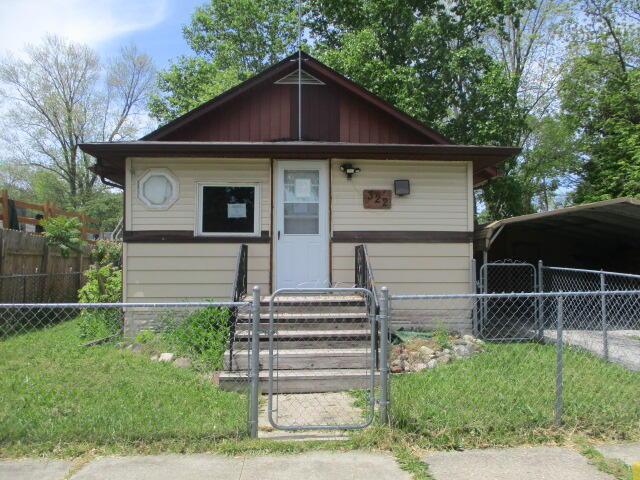 322 Crescent St, Watervliet, MI 49098 - bungalow-style home with a fenced front yard, a carport, and a gate