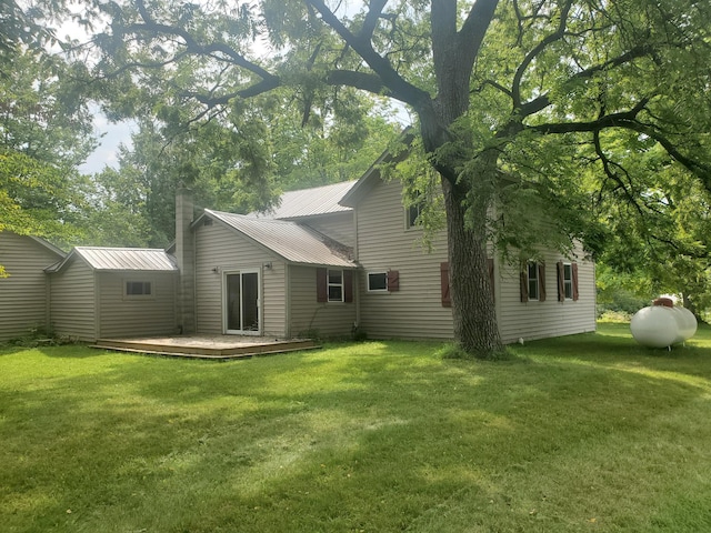 3354 E Arthur, Rothbury, MI 49452 - rear view of house with a yard, a chimney, a deck, and metal roof