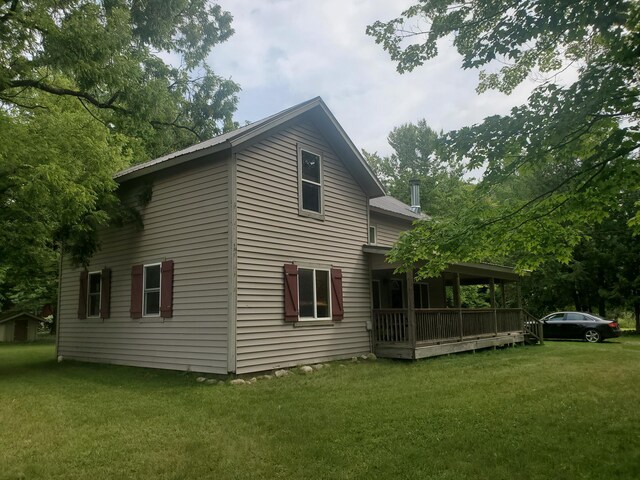 3354 E Arthur, Rothbury, MI 49452 - view of side of home featuring a lawn and a deck