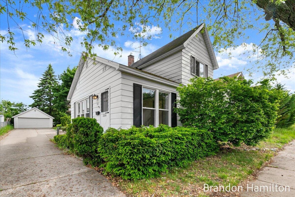 705 Burns St SW, Grand Rapids, MI 49503 - view of property exterior with a detached garage, a chimney, and an outbuilding