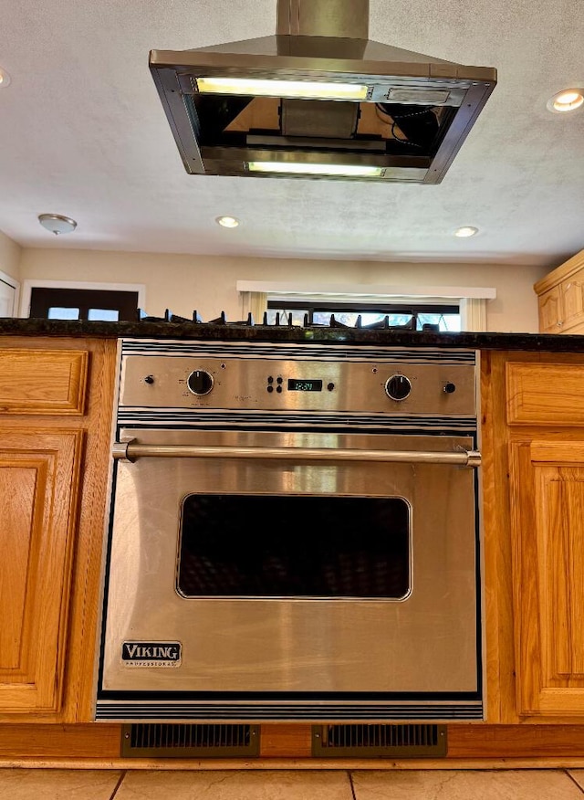 3671 Lido, Highland, MI 48356 - kitchen view of ventilation hood, dark countertops, recessed lighting, and brown cabinets