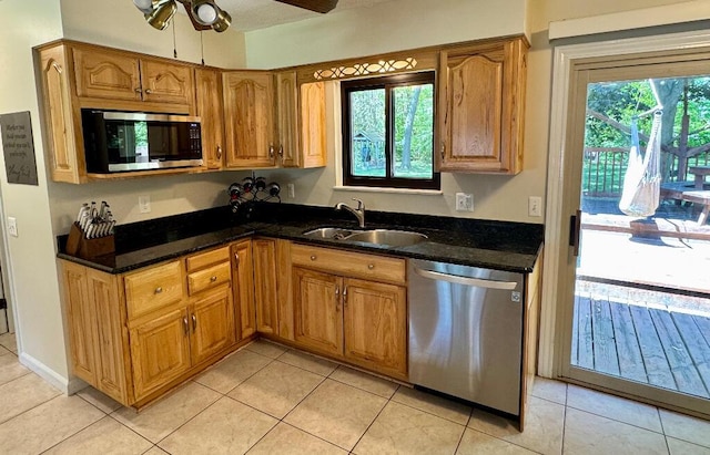 3671 Lido, Highland, MI 48356 - kitchen with appliances with stainless steel finishes, a sink, a ceiling fan, brown cabinetry, and light tile patterned floors