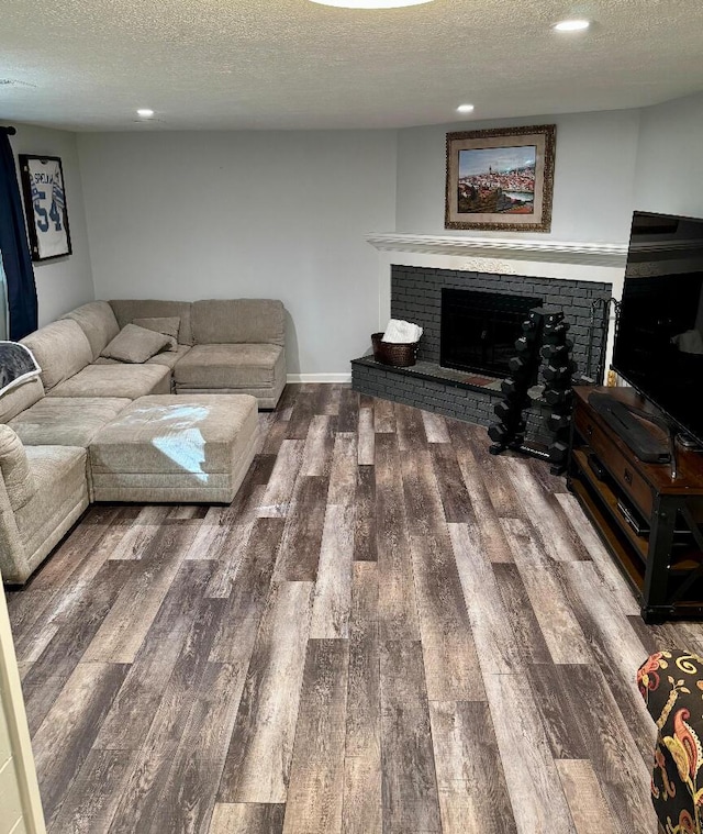 3671 Lido, Highland, MI 48356 - living room featuring a textured ceiling, a fireplace, wood finished floors, recessed lighting, and baseboards