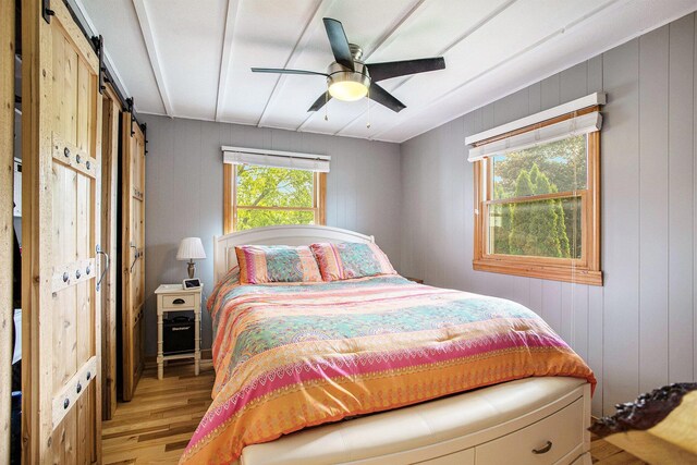 787 Doves Lndg, Coldwater, MI 49036 - bedroom with light wood-style floors, a barn door, and a ceiling fan