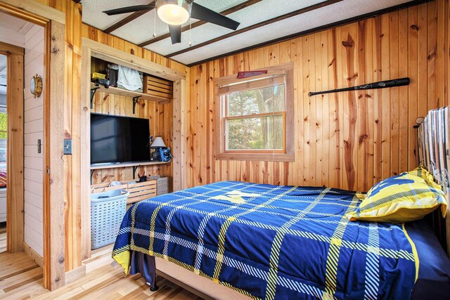787 Doves Lndg, Coldwater, MI 49036 - bedroom featuring wood walls, wood finished floors, a textured ceiling, and a ceiling fan