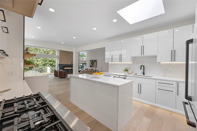 1752 Alexander Dr, Bloomfield, MI 48302 - kitchen featuring a sink, modern cabinets, freestanding refrigerator, white cabinets, and tasteful backsplash