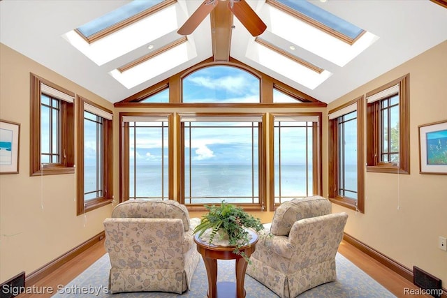 4150 Port Austin Rd, Caseville, MI 48725 - sitting room with a skylight, vaulted ceiling, light wood-style flooring, a ceiling fan, and baseboards
