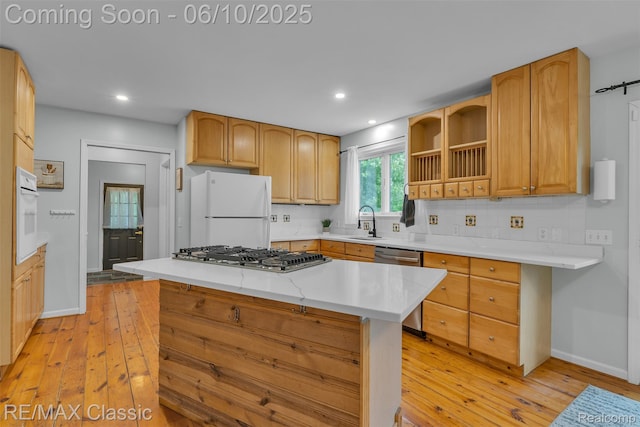917 Middle Rd, Highland, MI 48357 - kitchen with appliances with stainless steel finishes, a sink, light wood-type flooring, decorative backsplash, and baseboards