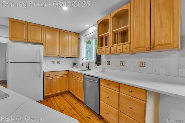917 Middle Rd, Highland, MI 48357 - kitchen featuring stainless steel dishwasher, freestanding refrigerator, a sink, light wood finished floors, and backsplash